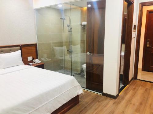 a bedroom with a bed and a glass shower at Doha 2 Hotel Saigon Airport in Ho Chi Minh City