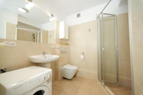 a bathroom with a sink and a washing machine at Apartament blisko plaży in Władysławowo