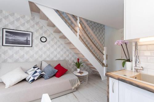 - un salon avec un canapé et un escalier dans l'établissement Apartamenty Bieg, à Ustka