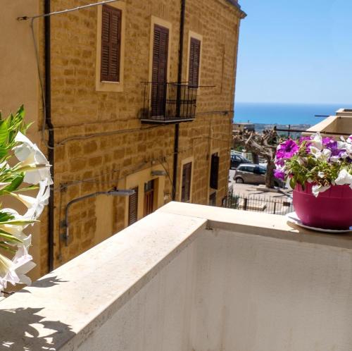 un balcón con una maceta de flores en una cornisa en La Passeggiata di Girgenti, en Agrigento