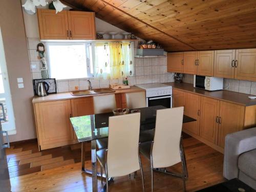 - une cuisine avec des placards en bois, une table et des chaises dans l'établissement Andreas Village, à Vassilias