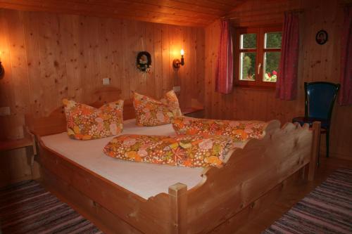 a bedroom with a large wooden bed with pillows at Ferienhaus Schnetzer in Sankt Gallenkirch