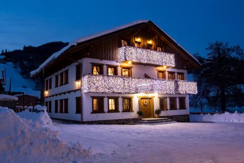 Un edificio coperto di luci natalizie nella neve di Amadehaus a Pruggern