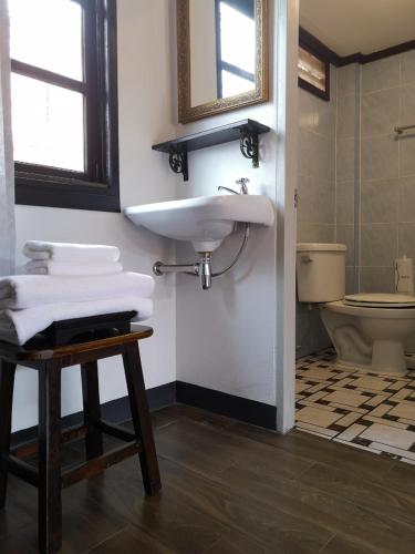 a bathroom with a sink and a toilet at RoongThoeng Place Hotel in Thoeng