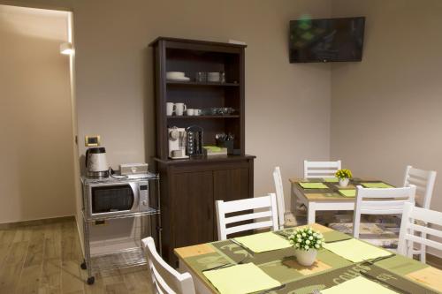 eine Küche und ein Esszimmer mit einem Tisch und Stühlen in der Unterkunft Home Syrakos B&B in Syrakus