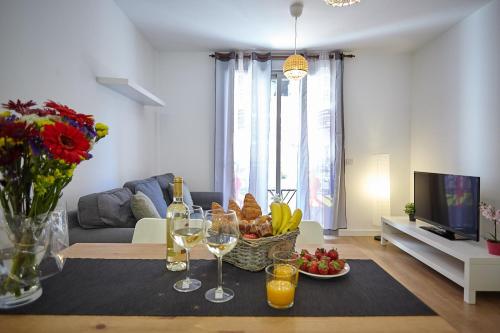 una sala de estar con una mesa con una cesta de frutas y copas de vino en Apartamento Sol y Mar I en Las Galletas