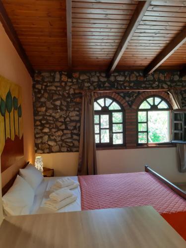 a bedroom with a bed and two windows at Eden Beach Hotel in Agia Marina Nea Kydonias