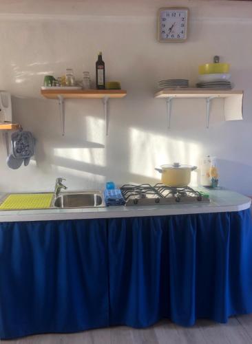 a kitchen counter with a blue table cloth on it at Li Cimi in San Pantaleo
