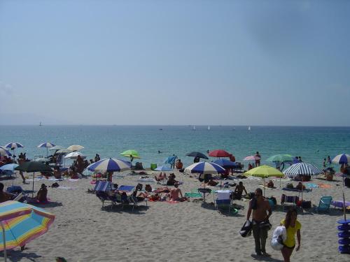a crowd of people on a beach with umbrellas at Rosanna House in Bombarde Beach in Alghero
