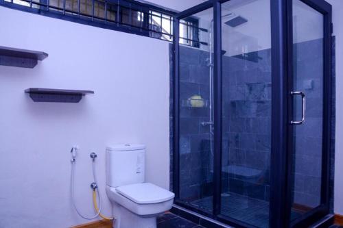 La salle de bains est pourvue de toilettes et d'une douche en verre. dans l'établissement Villa Oceane, à Pereybere