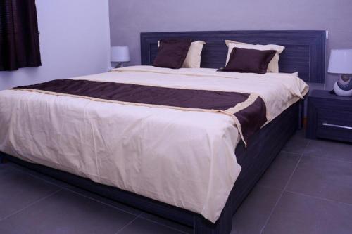 - un grand lit avec une tête de lit en bois dans une chambre dans l'établissement Villa Oceane, à Pereybere
