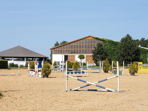 una spiaggia con un mucchio di attrezzature per il parco giochi di fronte a un edificio di Reitanlage Duffner a Horst