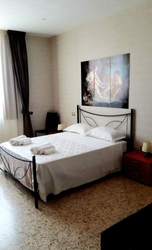 a bedroom with a large bed with white sheets at Domus Salentina in Leverano