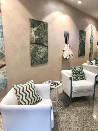 a room with two white chairs and a table at Grand Hotel Terme in Margherita di Savoia