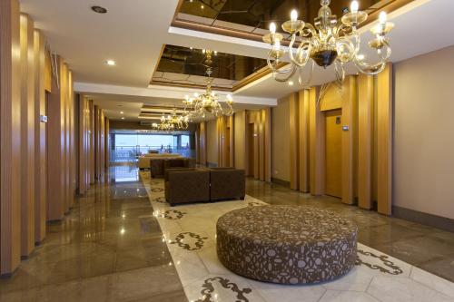 a lobby with a table and a chandelier at Xperia Saray Beach Hotel in Alanya