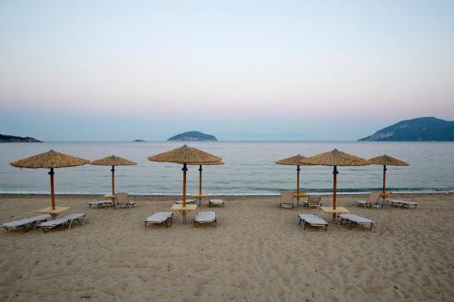 a group of chairs and umbrellas on a beach at Rent House Karavi in Iraklitsa