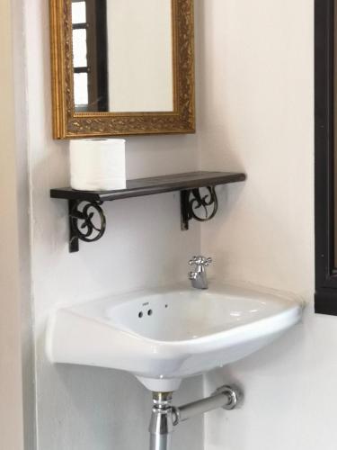 a white sink in a bathroom with a mirror at RoongThoeng Place Hotel in Thoeng