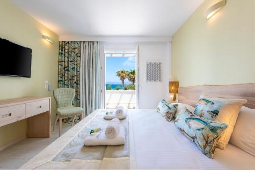 a hotel room with a bed with a view of the ocean at Saint George Hotel in Chrissi Akti