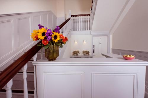 a vase of flowers sitting on a counter in a staircase at Best Luxury Apart Hotel in Oxford- Beechwood House in Oxford
