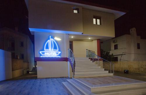 a lit up sign on a building with stairs at Rent House Karavi in Iraklitsa
