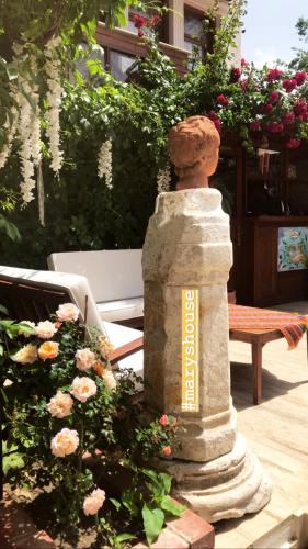 a statue sitting in the middle of a garden at Hotel Mary's House in Selcuk