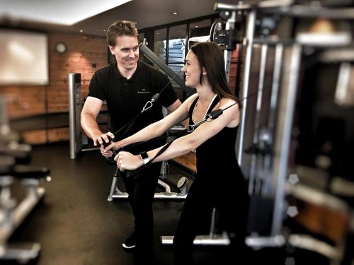 a man and a woman exercising in a gym at Åkerblads Hotell Gästgiveri Spa in Tällberg