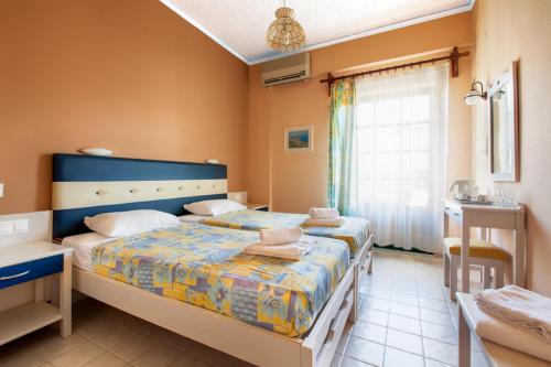 a bedroom with two beds and a window at Rea Hotel in Palaiochora