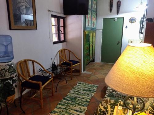 a living room with chairs and a green door at Casa de Como in Ajijic