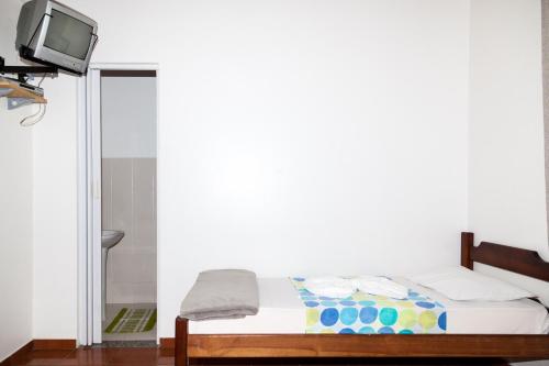 sypialnia z łóżkiem z telewizorem na ścianie w obiekcie Pousada do Genesio w mieście Petrópolis