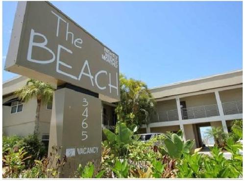 a sign for the beach in front of a building at The Beach on Longboat Key in Longboat Key