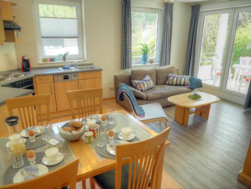a kitchen and living room with a table and a couch at Fewo No.43 am Rathaus in Willingen