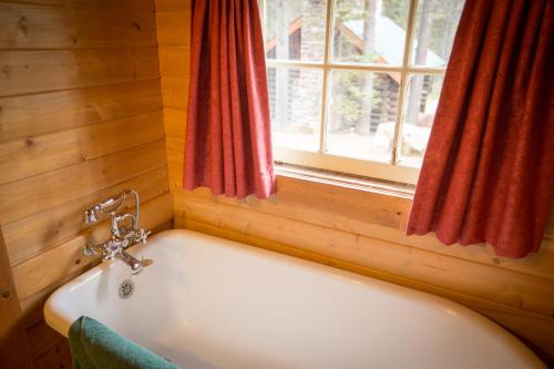 a white bath tub in a room with a window at Storm Mountain Lodge & Cabins in Banff