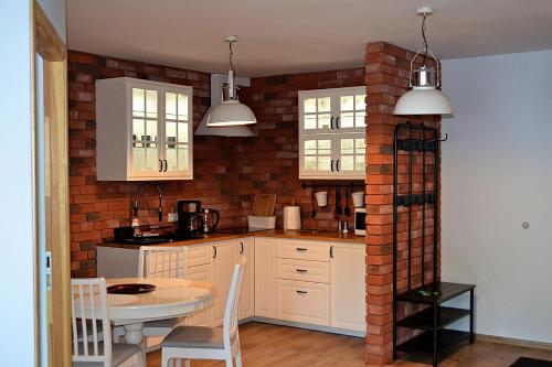 uma cozinha com uma mesa e uma parede de tijolos em Apartament Uśmiech em Ustrzyki Dolne