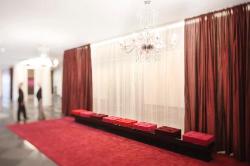 a room with a red carpet and a chandelier at Mövenpick Hotel Stuttgart Airport in Stuttgart