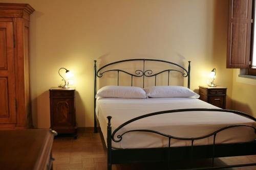 a bedroom with a bed with two lamps on the sides at Agriturismo Cavrigo in Lodi