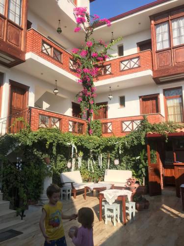 two children standing in front of a building with flowers at Hotel Mary's House in Selcuk