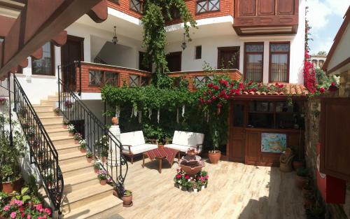 a woman sitting on a porch of a house with flowers at Hotel Mary's House in Selcuk