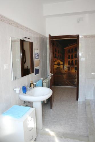 a white bathroom with a sink and a mirror at La casa dei nonni in Iglesias