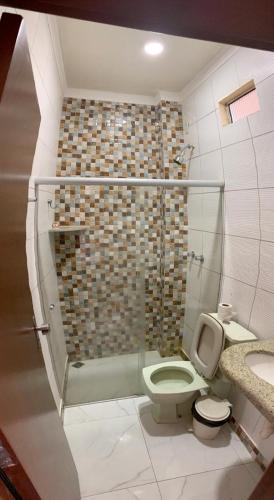 a bathroom with a shower and a toilet and a sink at Hotel Santana - Posto da Mata BA in Pasto da Mata