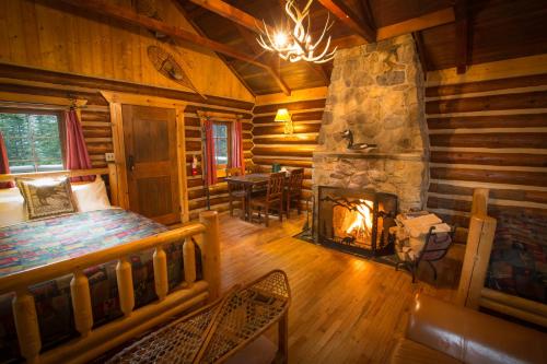 a bedroom with a fireplace in a log cabin at Storm Mountain Lodge & Cabins in Banff