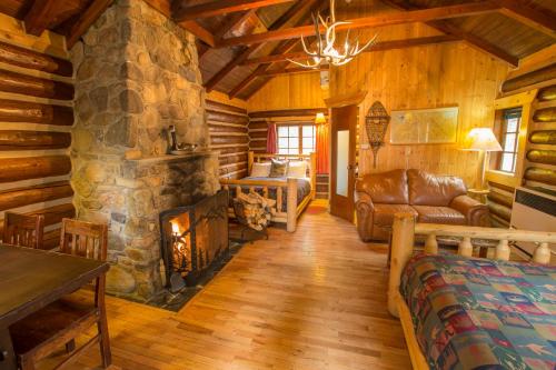 a living room with a fireplace in a log cabin at Storm Mountain Lodge & Cabins in Banff