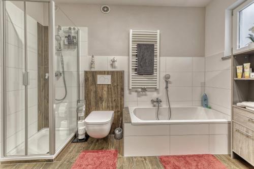 a bathroom with a tub and a toilet and a shower at Ferienwohnung Fernblick in Neukirchen vorm Wald