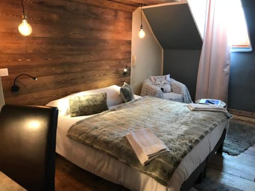 a bedroom with a bed and a wooden wall at Auberge de la Paix in Briançon