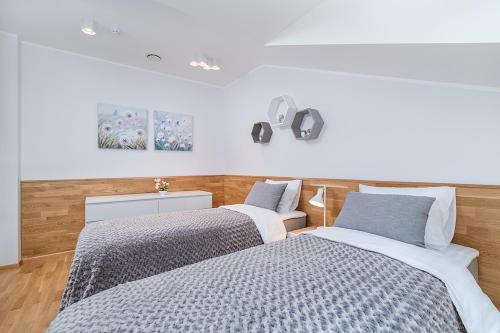 2 camas en un dormitorio con paredes blancas y suelo de madera en Rooftop Apartments, en Tallin
