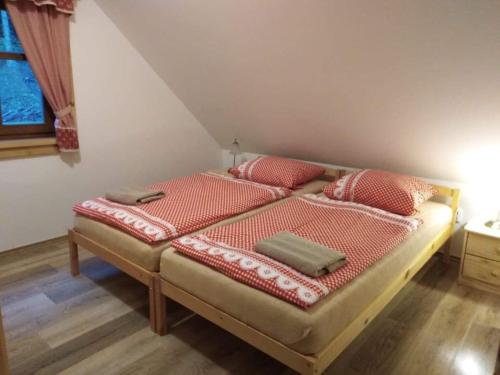 a bedroom with two beds with red pillows at Chalupa na Leskové in Velké Karlovice