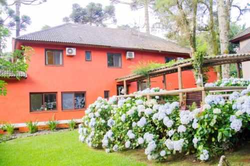 a house with a bunch of flowers in front of it at Pousada Pinhão e Poesia in Canela