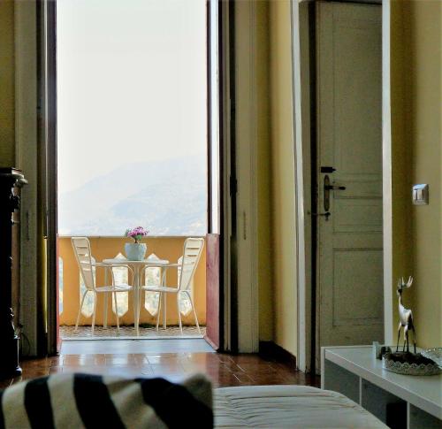 ヴィーコ・エクエンセにあるDimora del Conte Sorrento coast seaviewのテーブルと椅子、大きな窓が備わる客室です。