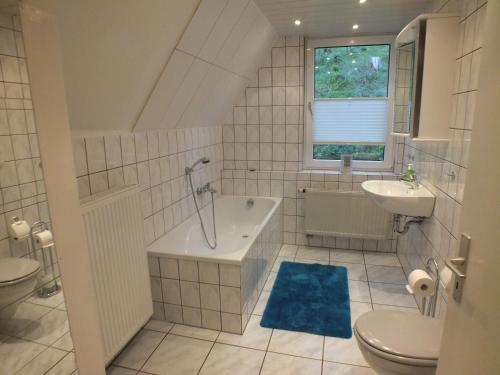 y baño con bañera, lavabo y aseo. en Haus Sonnenblick, en Oberschönau