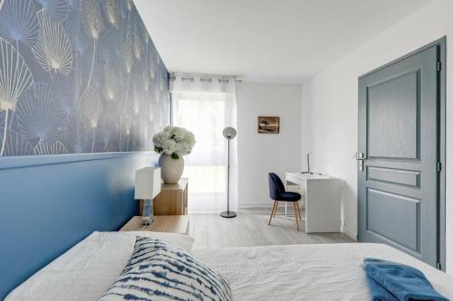 une chambre avec un lit avec un mur bleu dans l'établissement Le paradis de Lila, à Mont-Saint-Aignan