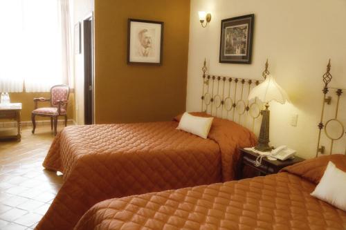 a hotel room with two beds and a telephone at El Meson de los Poetas in Guanajuato